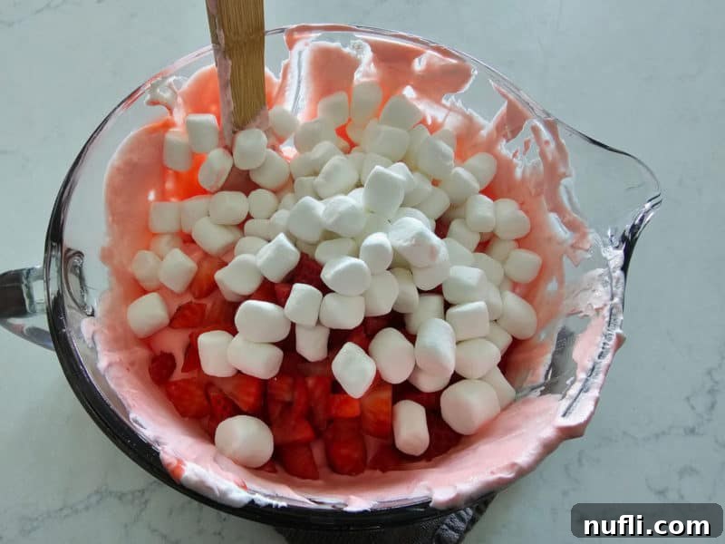 Strawberry Cloud Delight 7 Mini marshmallows and strawberries on top of strawberry fluff in a glass bowl