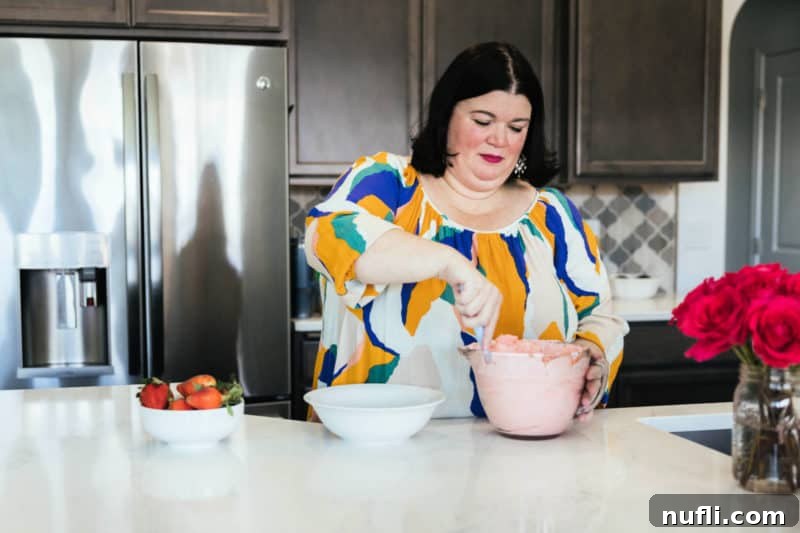 Strawberry Cloud Delight 9 Tammilee stirring strawberry fluff salad in home kitchen