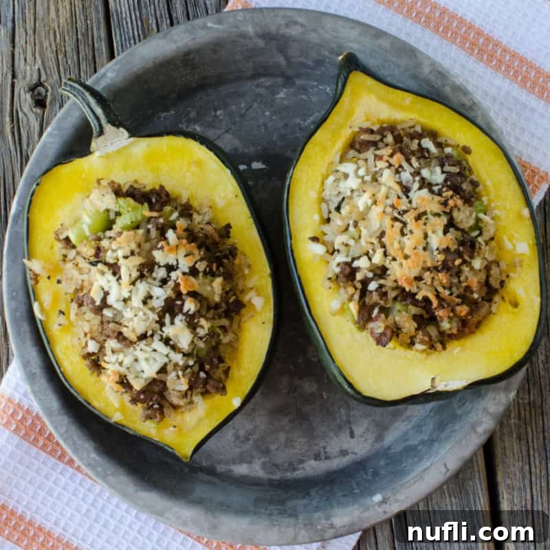 Hearty Sausage and Rice Stuffed Acorn Squash, beautifully plated on silver with a cloth napkin.