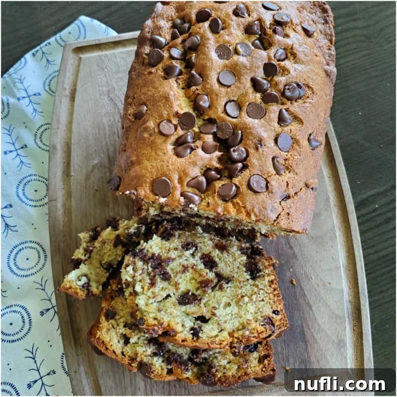 Chocolate Chip Banana Bread on a wooden board next to a cloth napkin