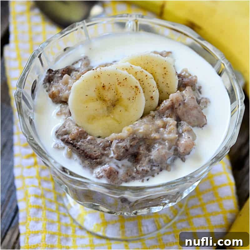 Banana Bread oatmeal with banana slices in a glass bowl on a yellow napkin
