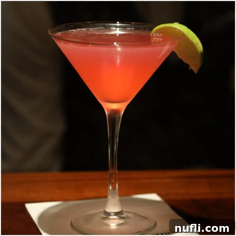 Pink martini in a martini glass with lime wedge