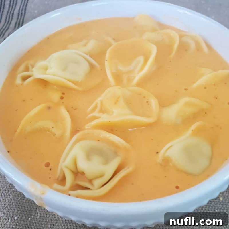 Slow Cooker Tomato Tortellini Soup in a white bowl