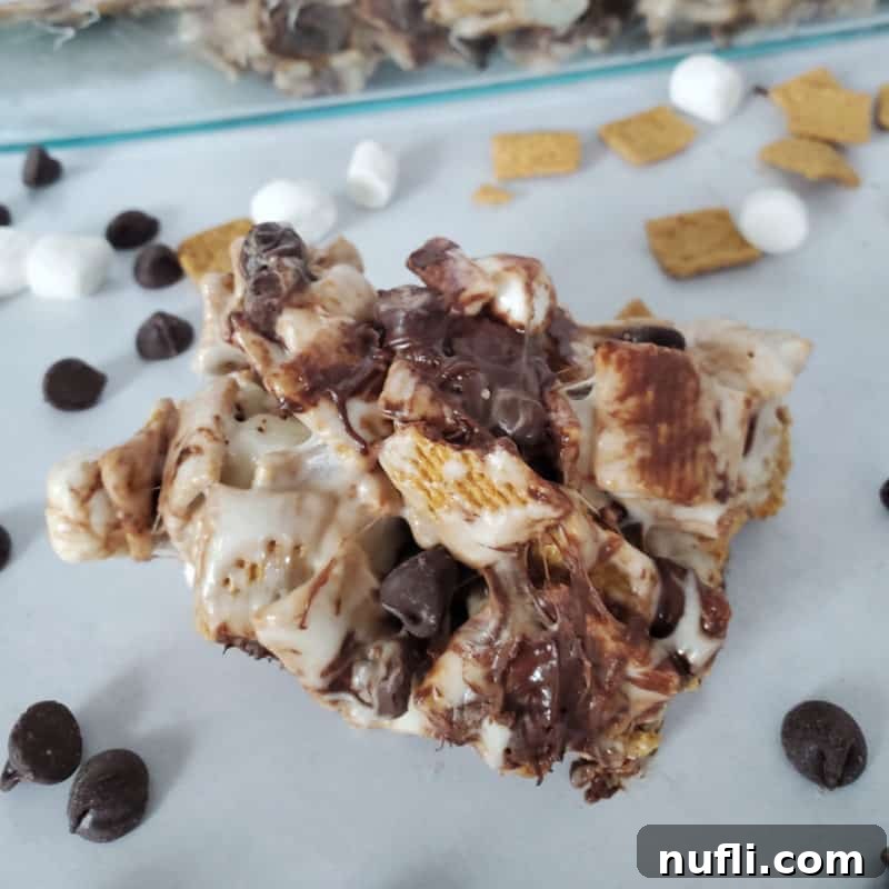 S’mores Golden Graham Bar in front of a baking dish with chocolate chips and marshmallows