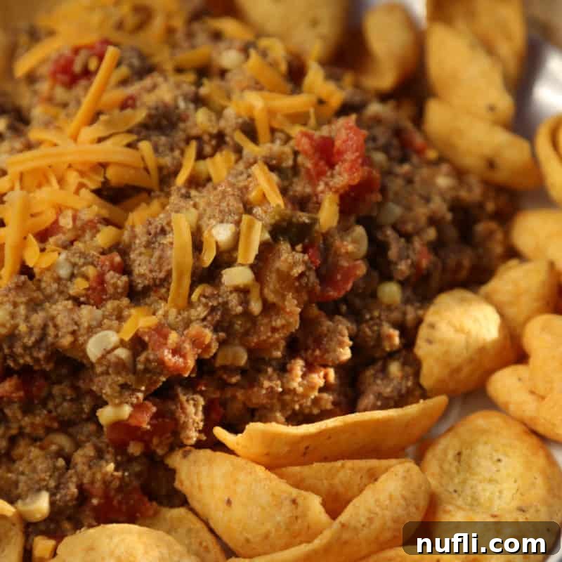 Spicy taco beef with cheese next to Frito Chips