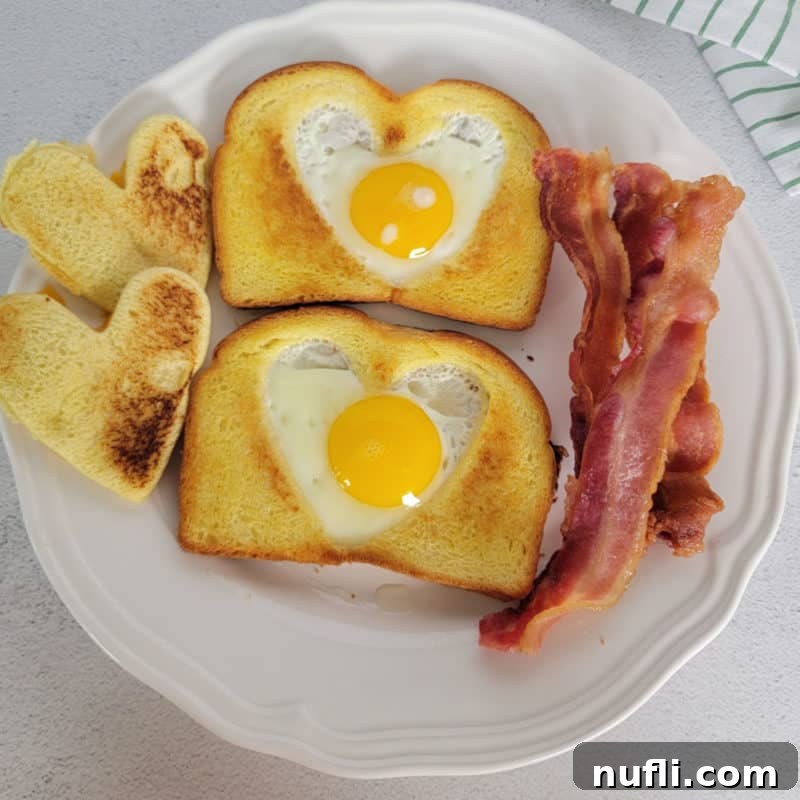 Classic Eggs in a Basket, with an egg perfectly cooked in the center of toasted bread, served alongside crispy bacon.