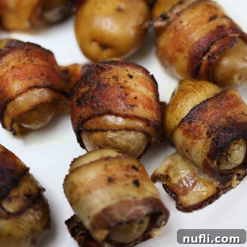 Bacon wrapped baby potatoes on a white plate