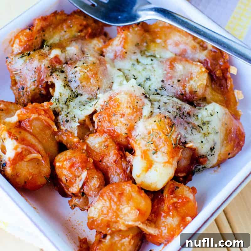 A delightful Gnocchi Casserole, rich with cheesy sauce and tender potato dumplings, served in a white bowl with a fork.
