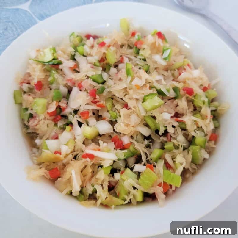 Sauerkraut Salad in a white bowl next to a fork