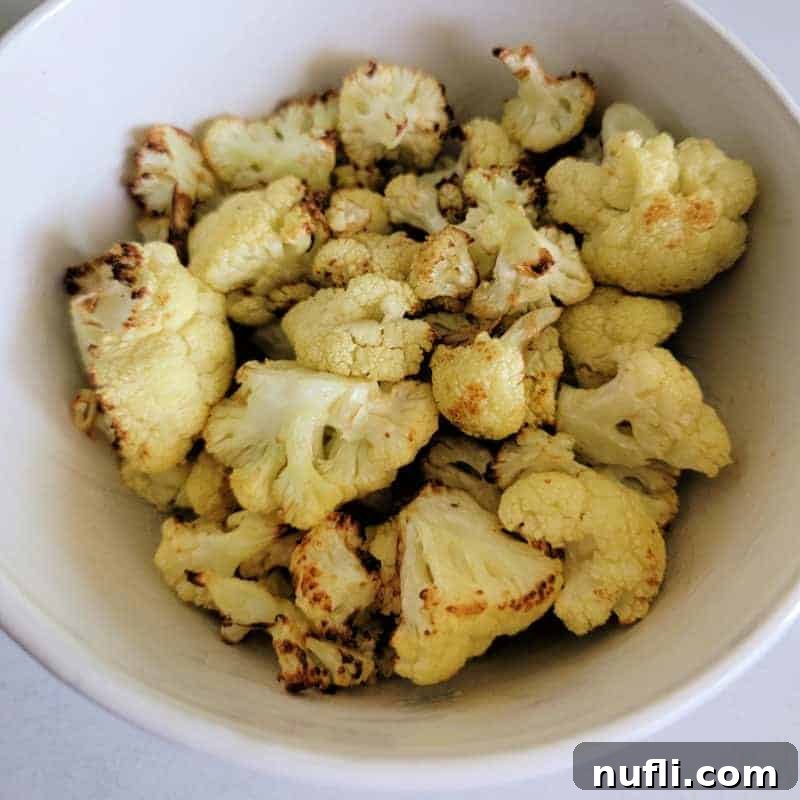 Crispy Air Fryer Cauliflower florets, seasoned and roasted to perfection, served in a white bowl as a healthy and flavorful vegetable side.