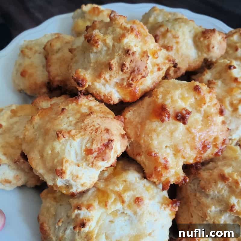 A stack of golden-brown Cheddar Bay Biscuits, rich with cheese and garlic, presented on a white plate, invitingly ready to be enjoyed.
