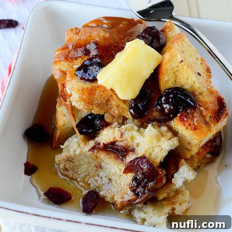 Crockpot Eggnog French toast displayed on a white plate with a fork, ready to be enjoyed.
