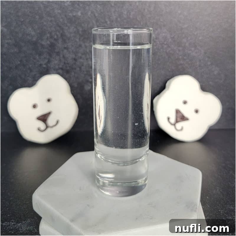 polar bear marshmallows behind a shot glass with clear liquid polar bear shot