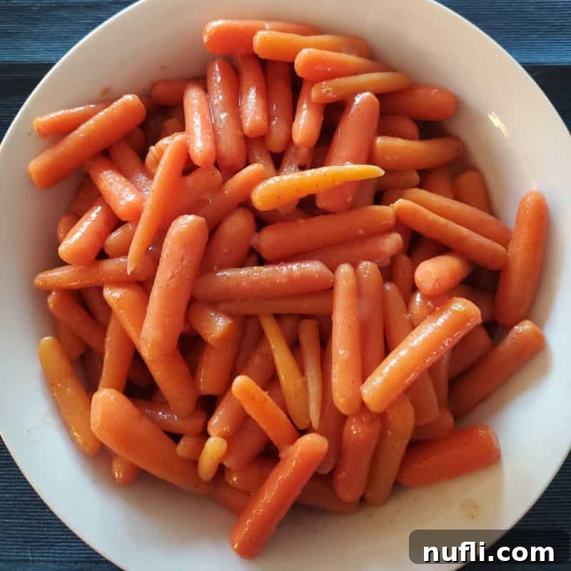 Sweet and savory glazed carrots served in a elegant white bowl.