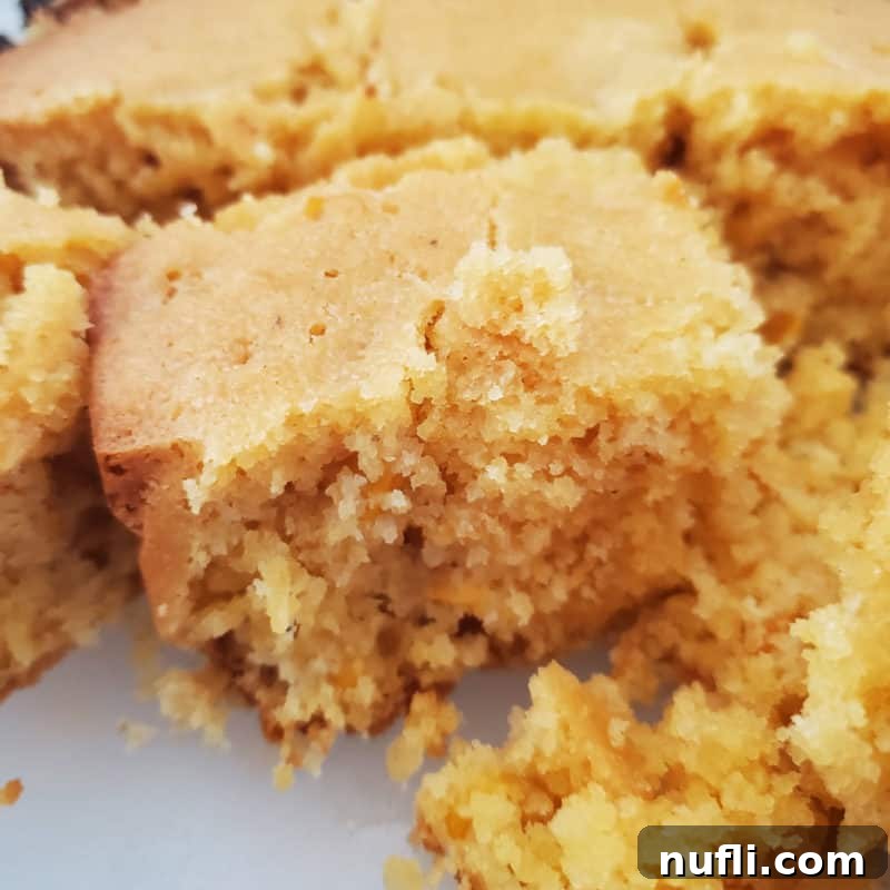 Golden-brown squares of Crockpot Cornbread neatly arranged on a white platter.