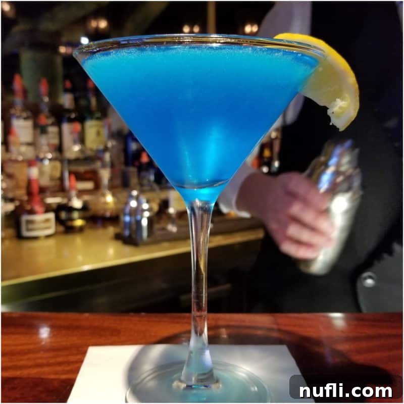 Sea Blue Martini in a martini glass with lemon wedge