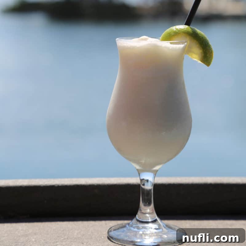 Key Lime Colada in a hurricane glass with lime wedge garnish