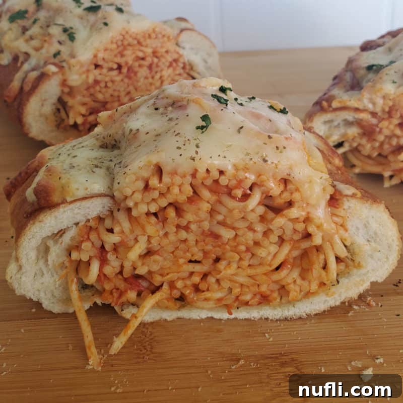Spaghetti Stuffed Garlic Bread served on a rustic wooden cutting board, a creative fusion of two beloved comfort foods.