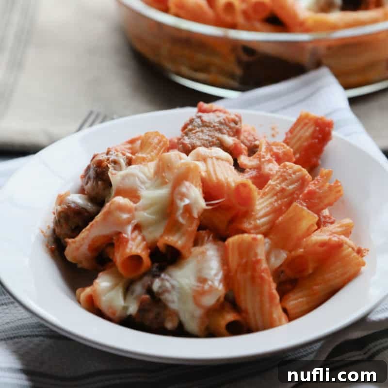 A white bowl brimming with Baked Rigatoni and Mini Meatballs, a cheesy and hearty pasta dish, ready to be savored.