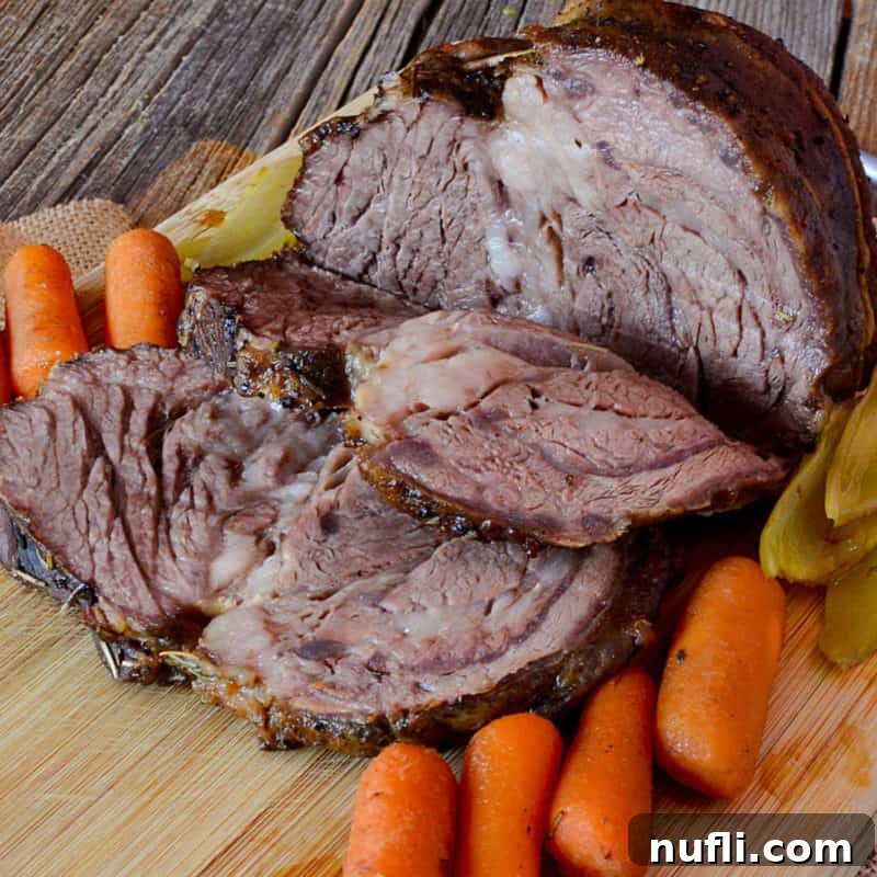Slices of perfectly cooked Crockpot Roast arranged on a cutting board with tender carrots, ready for a comforting meal.