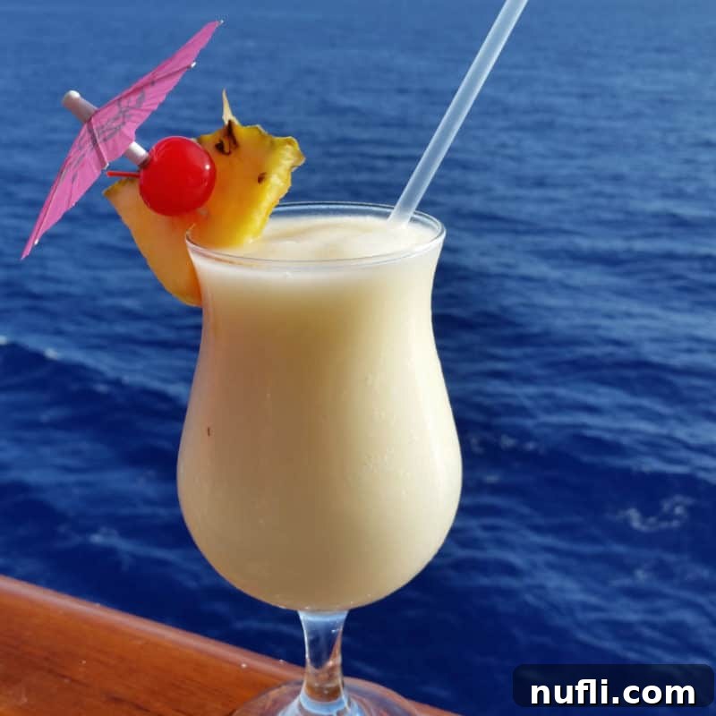 Tropical Pineapple Cocktails Made Easy 14 Caribbean Colada in a hurricane glass with pineapple wedge and cherry garnish