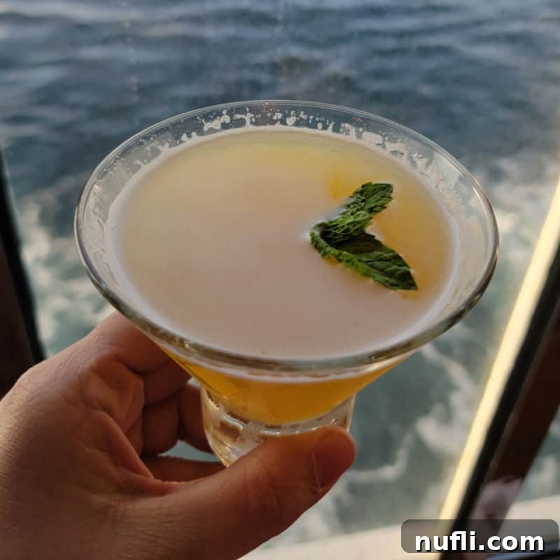 Tropical Pineapple Cocktails Made Easy 15 Spicy Chipotle martini in a stemless martini glass with ocean water in the background