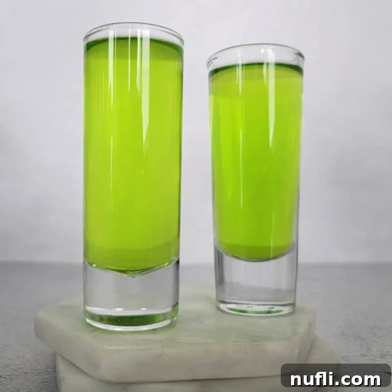 Tropical Pineapple Cocktails Made Easy 5 Two bright green ninja turtle shots on white coasters