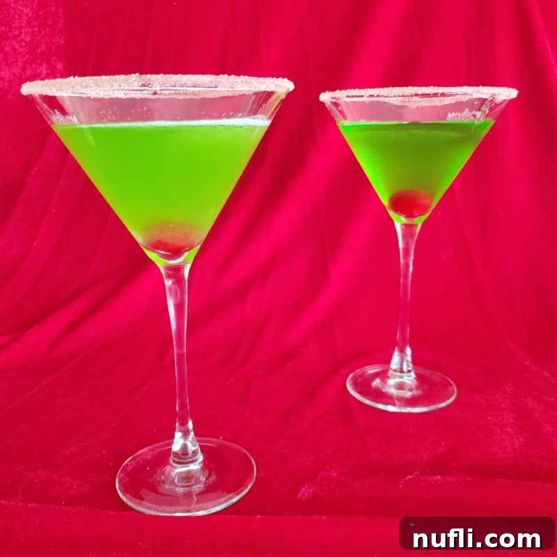 Tropical Pineapple Cocktails Made Easy 6 Two Bright green cocktails with cherries in them in martini glasses with a sugared rim.