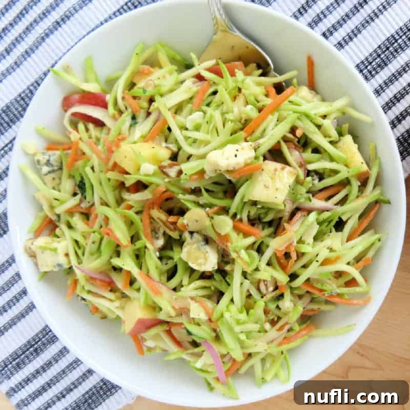 Broccoli slaw in a white bowl with a fork