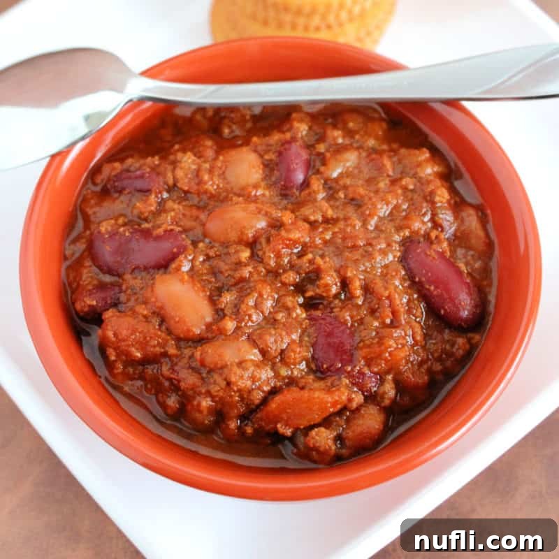 Wendy’s Chili in an orange bowl with a spoon on it