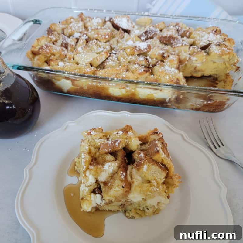 square of overnight French toast on a white plate in front of a casserole dish filled with French Toast casserole