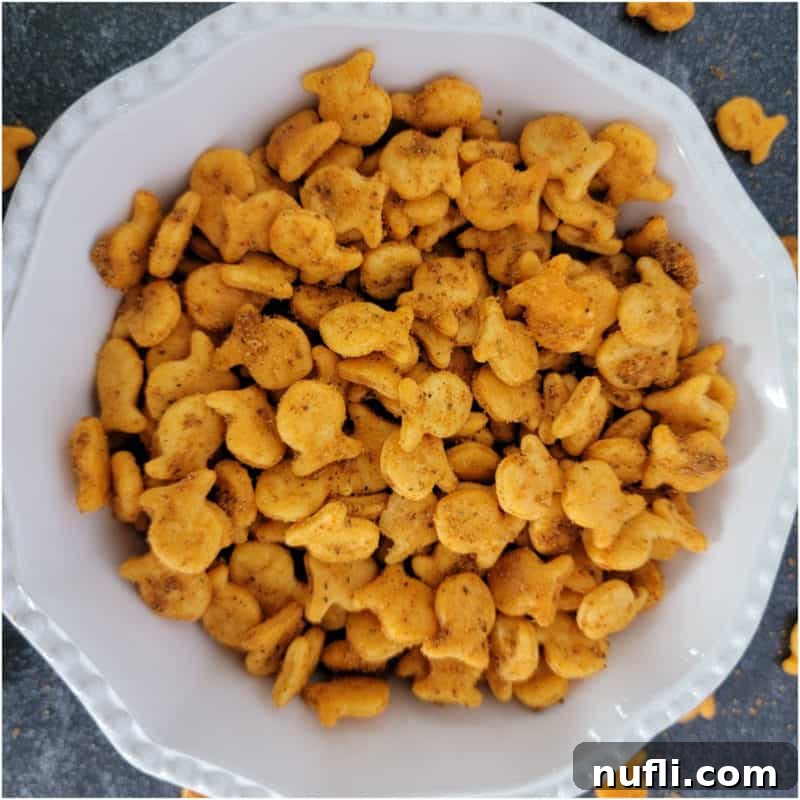A pristine white bowl brimming with zesty 3-Ingredient Old Bay Goldfish Crackers, seasoned to a spicy perfection.