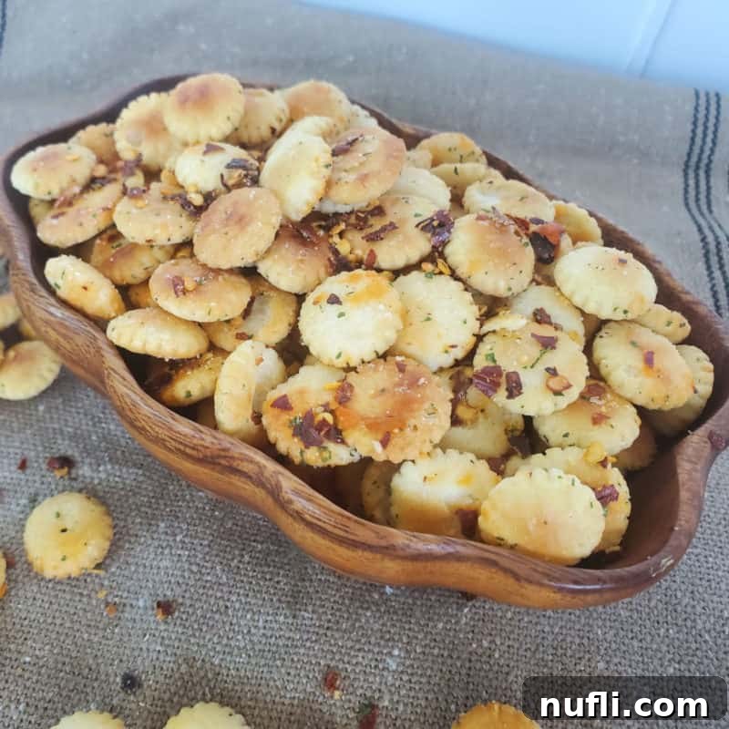 Spicy oyster crackers, perfectly seasoned and presented in a charming wooden bowl, resting on a rustic burlap cloth for a cozy aesthetic.