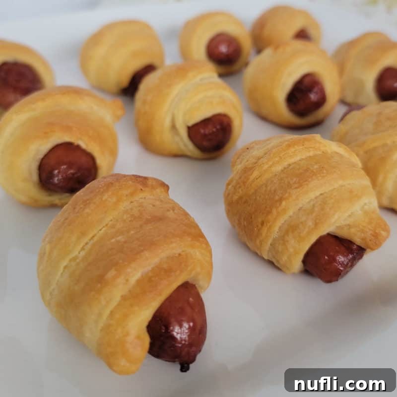 A plate of classic Pigs in a Blanket, golden-brown and perfectly baked, arranged for easy serving and enjoyment.