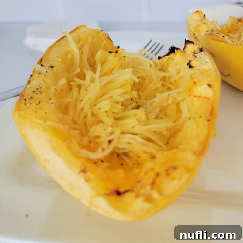 Spaghetti squash on a white plate next to a fork