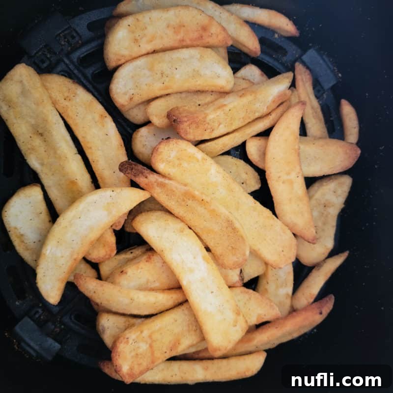 Over 30 Essential Sides for Burger Enthusiasts 18 Crispy air-fried French fries perfectly cooked in an air fryer basket, ideal for pairing with burgers.