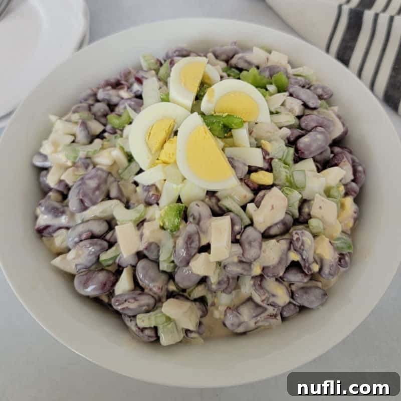 Over 30 Essential Sides for Burger Enthusiasts 6 A bowl of refreshing Kidney Bean Salad, topped with pieces of hard-boiled egg, ready to serve as a side dish.