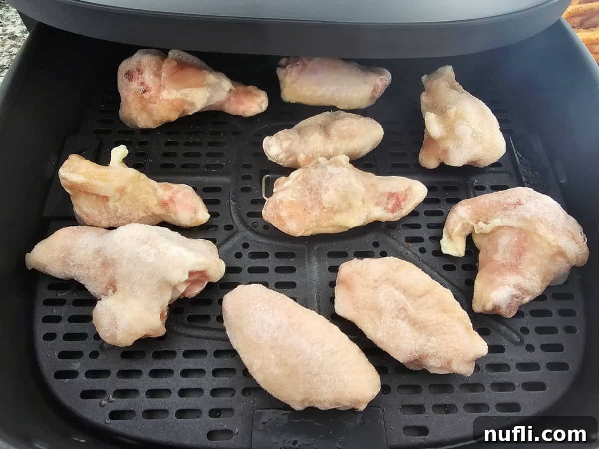 frozen chicken wings in an air fryer basket