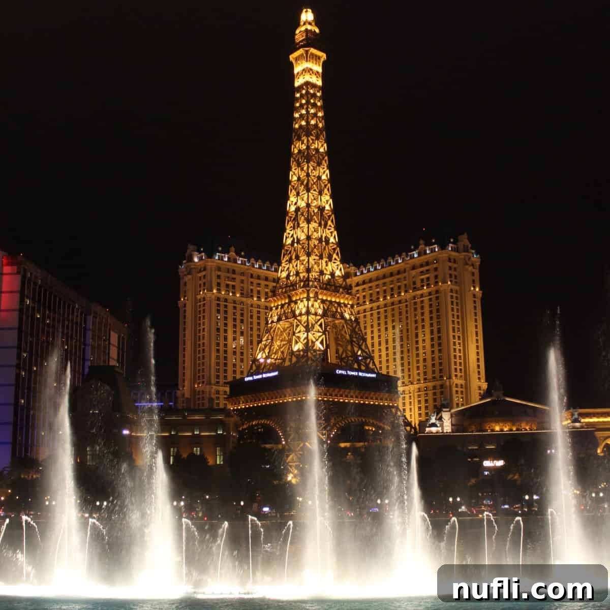 Bellagio Fountains with the Paris Eiffel Tower lit up in the background