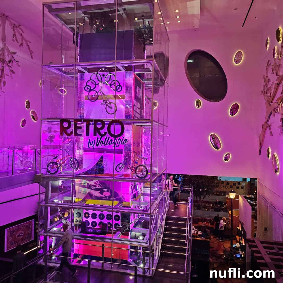 Retro by Volttaggio sign in a clear large box with records, bikes and retro toys next to stairs down into the restaurant.