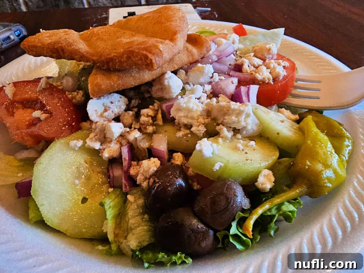 Fresh Greek salad in a white bowl with a fork on the side, ready to be enjoyed.