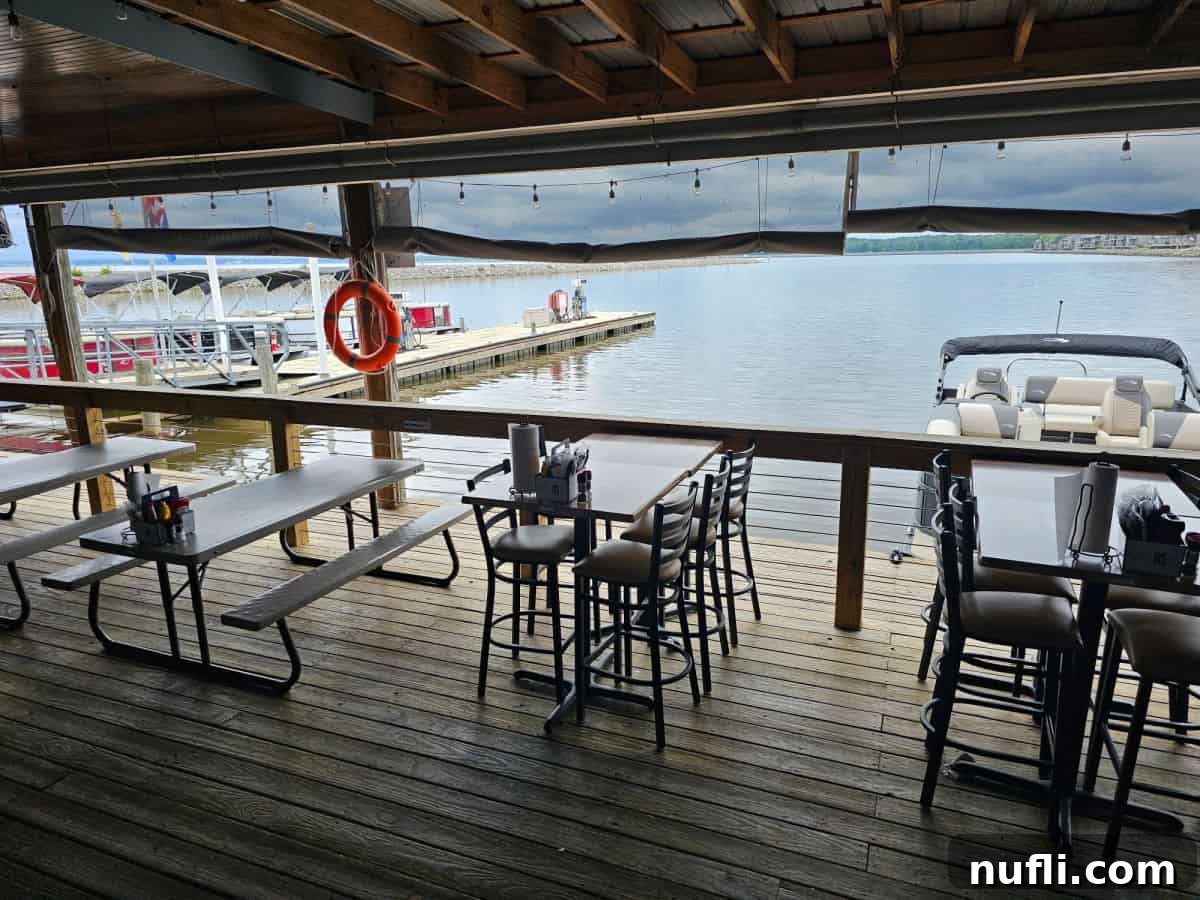 Restaurant deck with tables, offering a picturesque view of the water and docked boats.