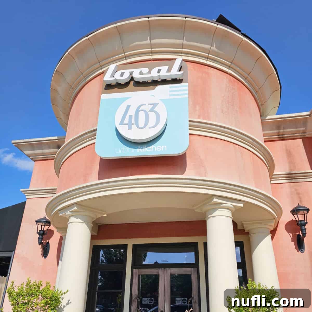 Local 463 sign on a pink brown building over the main entrance, welcoming diners.