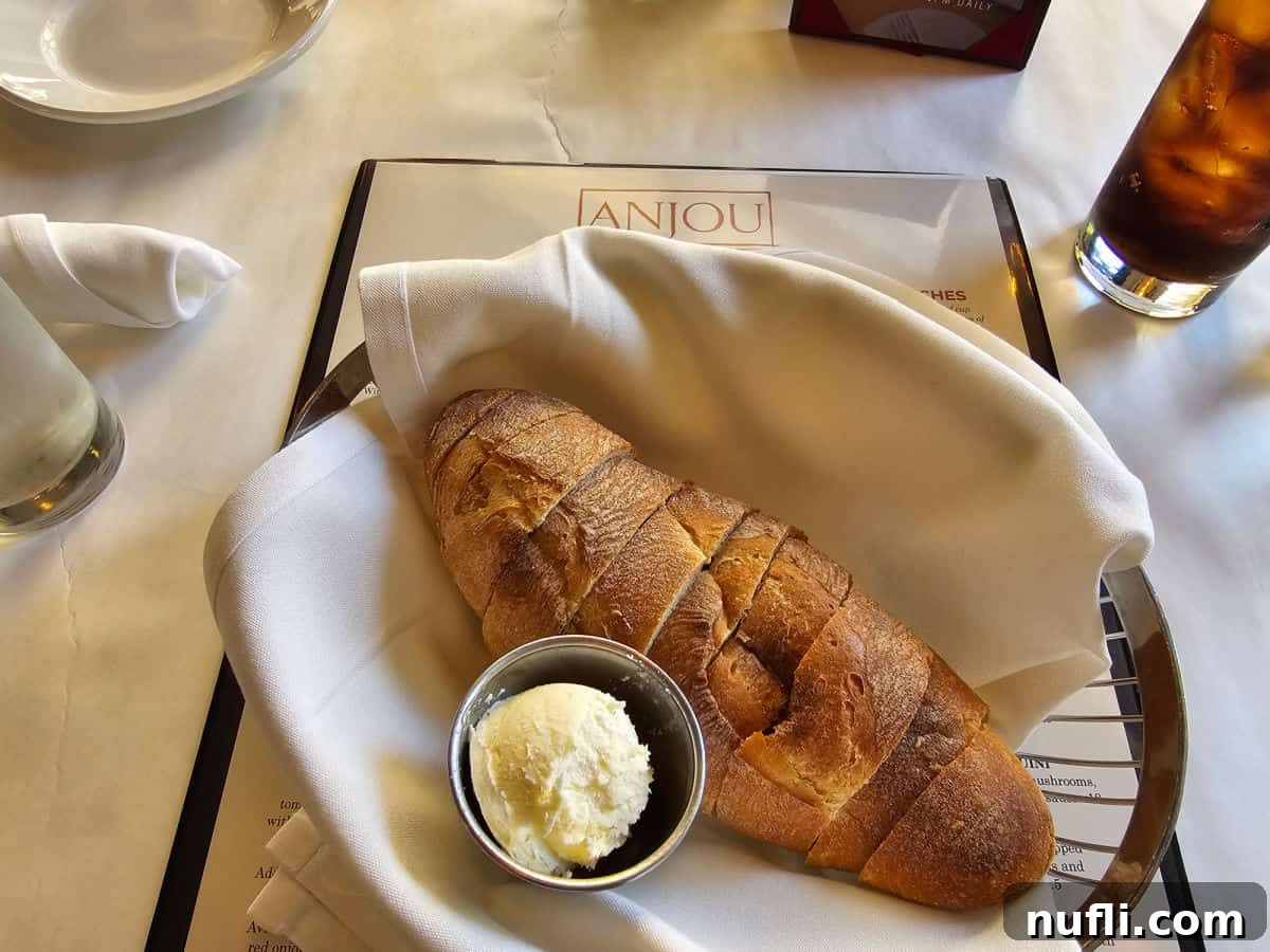 Basket of sliced bread with whipped butter on an Anjou restaurant menu.