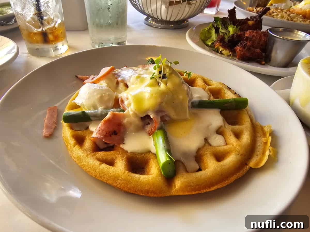 Savory waffle dish topped with ham, fresh asparagus, and rich mornay sauce.