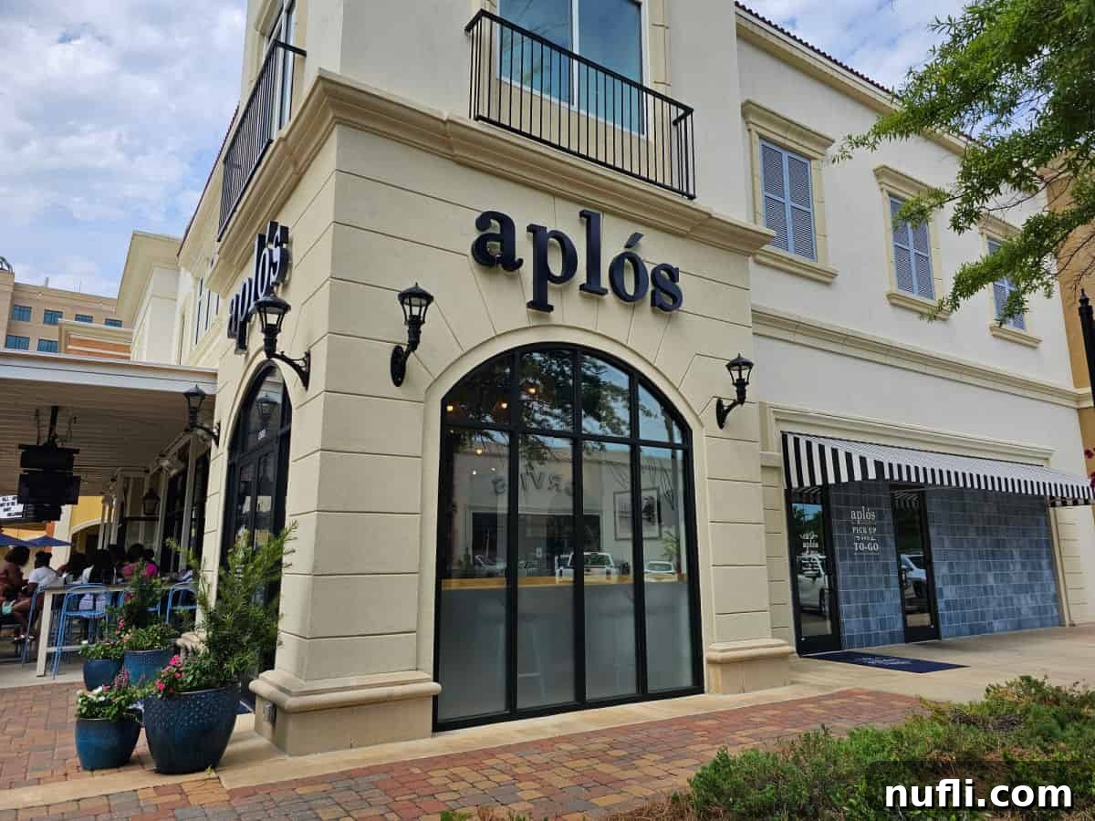 Aplos restaurant exterior with large windows and a patio to the left.