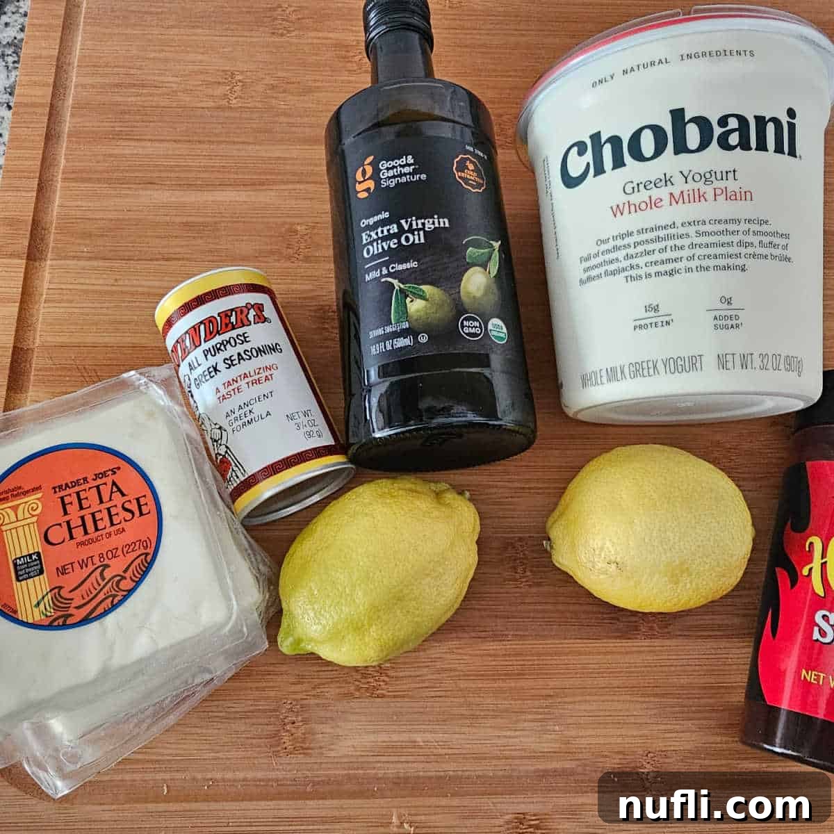 feta, Greek seasoning, olive oil, plain Greek yogurt, lemons on a cutting board