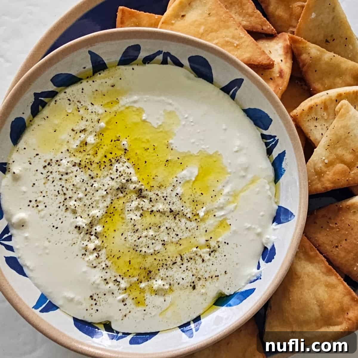 whipped feta dip in a bowl next to pita chips