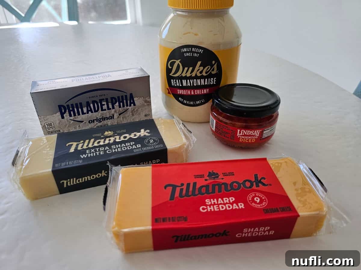 Duke's mayo, cream cheese, tillamook cheese, and a jar of diced pimentos on a white table