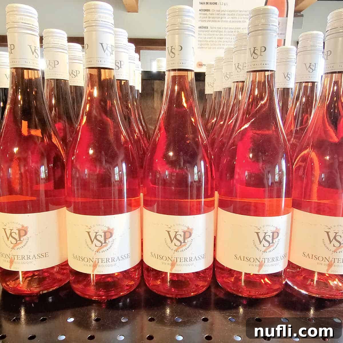 A row of 'VSP Saison Terrasse' wine bottles elegantly displayed on a shelf, showcasing the vineyard's offerings